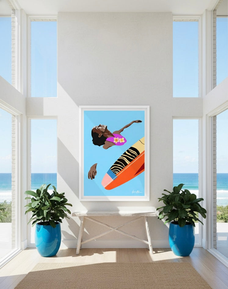 Art print painting of a woman in a pink swimsuit with frangipani flowers, floating on calm blue water with her colourful surfboard, displayed in a bright room with large windows.