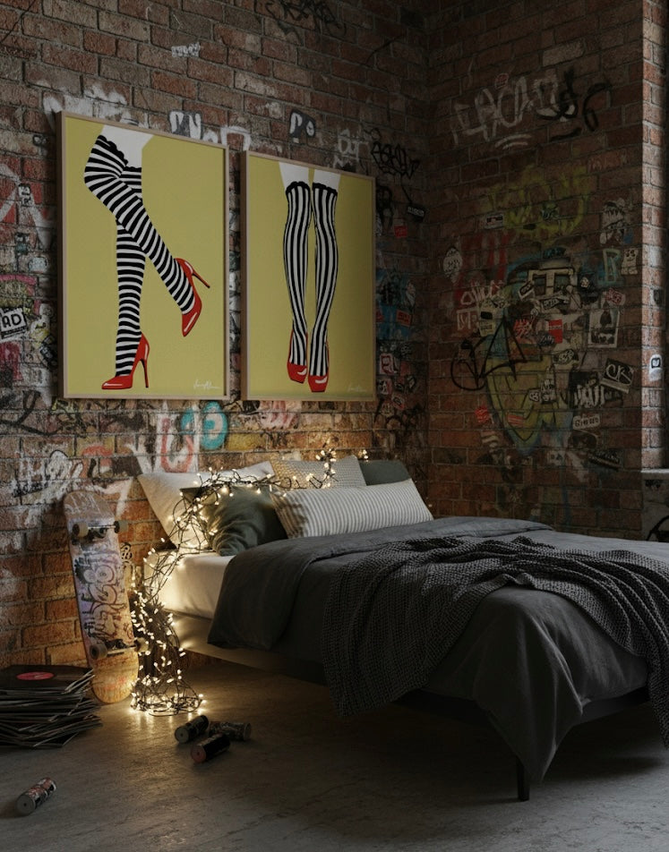 Two art prints of black and white striped stockings with red high heels on a golden yellow background in a urban bedroom.