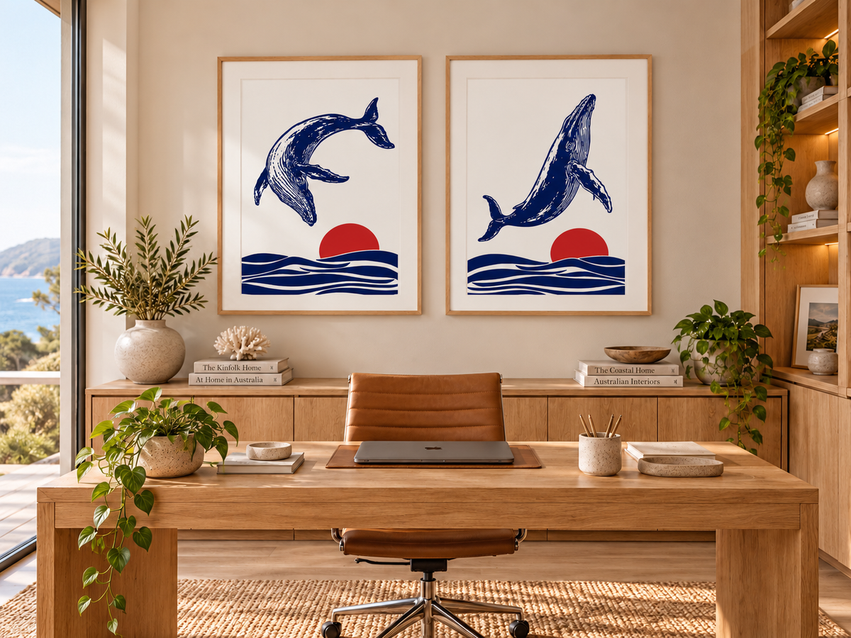The Leap and The Turning contemporary humpback whale art prints by Ilana McBain displayed side by side in a warm modern coastal home office with timber furniture and natural light.