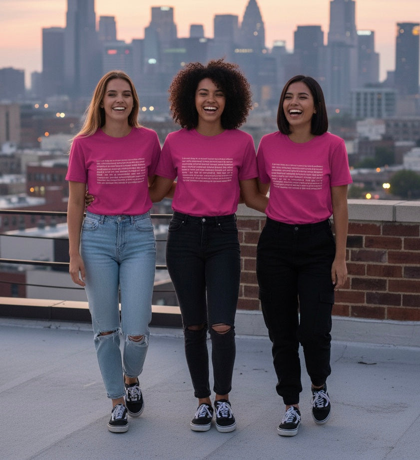 Three women wearing pink t-shirts with a city skyline in the background