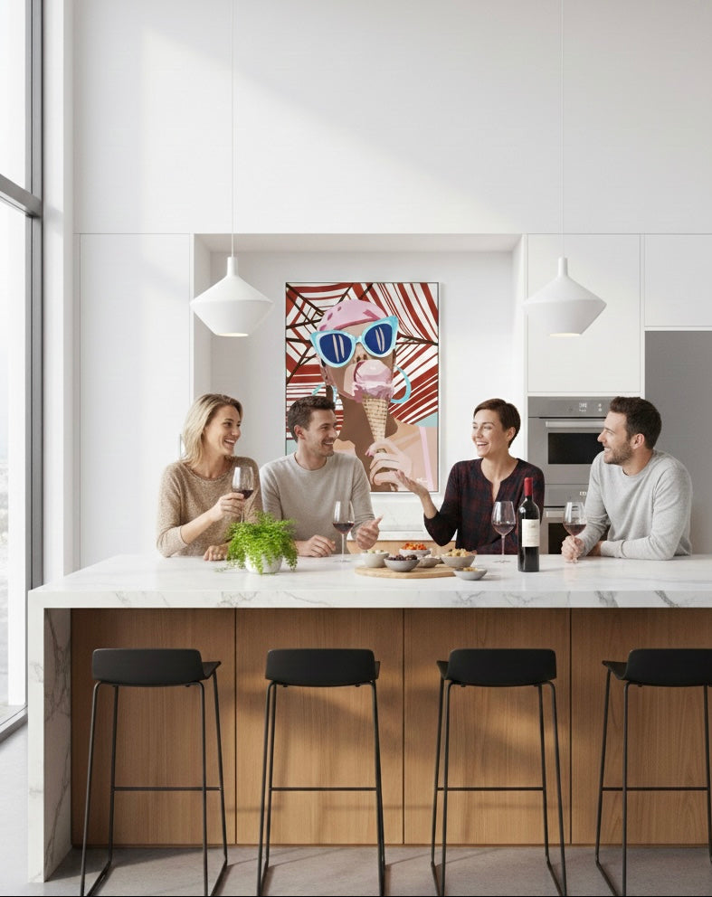 People sitting around a kitchen island with modern decor and girl eating ice cream painting by ilana mcbain artwork on the wall.