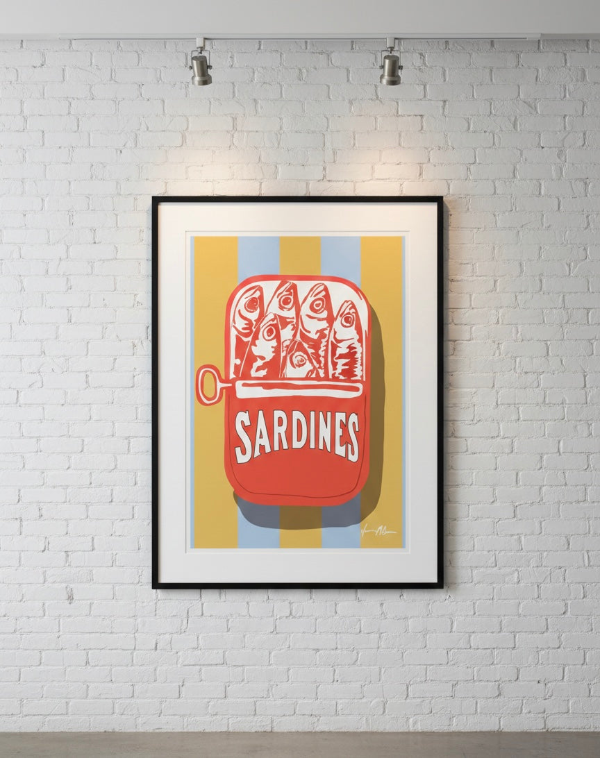 Framed artwork of red sardine in a can with  on a gold and blue stripe background, mounted on a white brick wall.