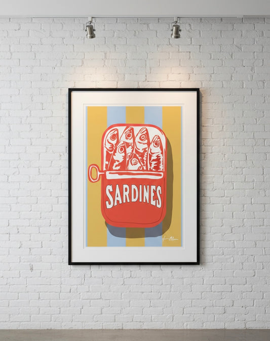 Framed artwork of red sardine in a can with  on a gold and blue stripe background, mounted on a white brick wall.