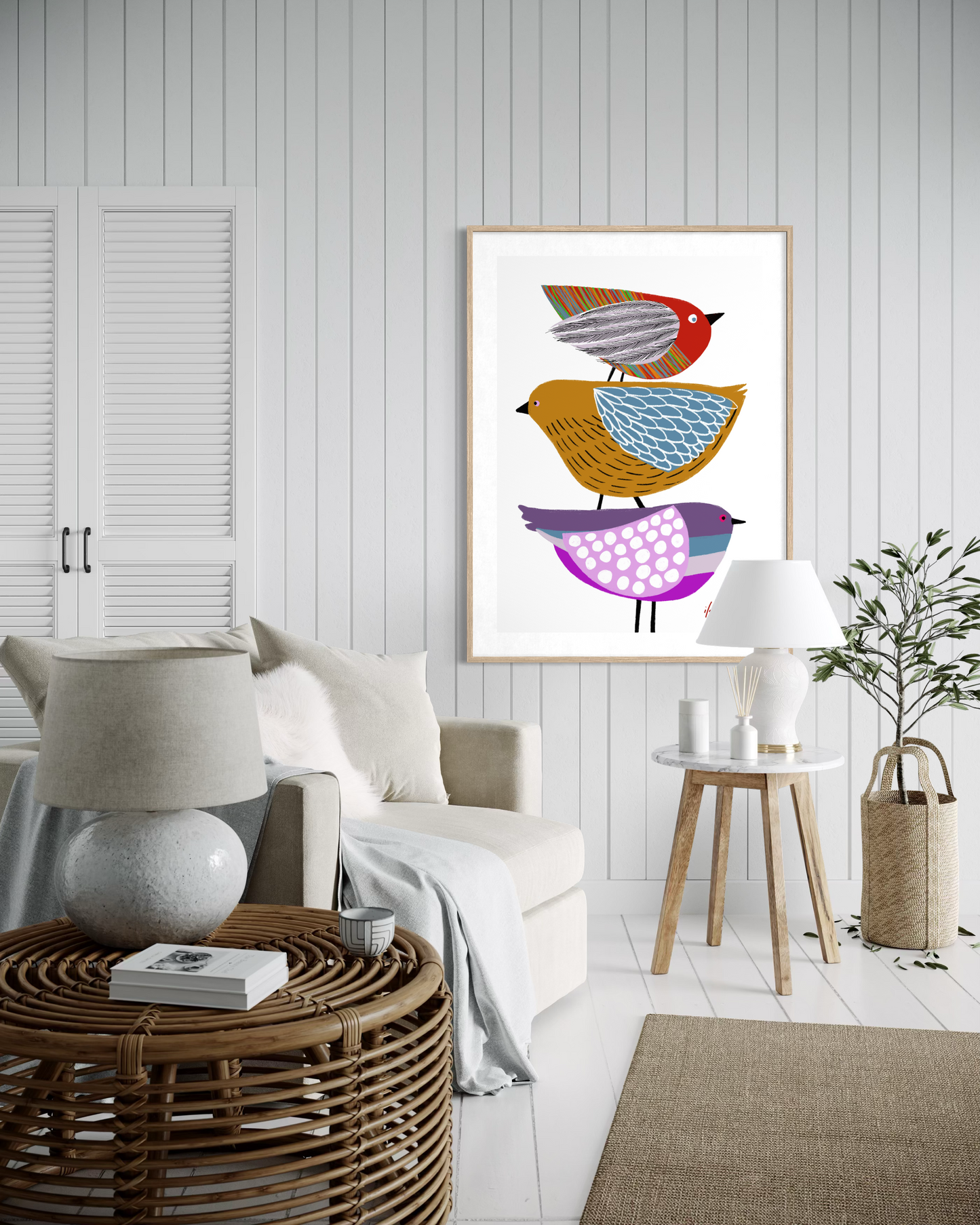 Stack of Birds artwork by Australian artist Ilana McBain featuring three colourful stylised birds stacked together, displayed in a modern light-filled living room interior with contemporary coastal decor. Fine art wall print on museum quality cotton rag paper.