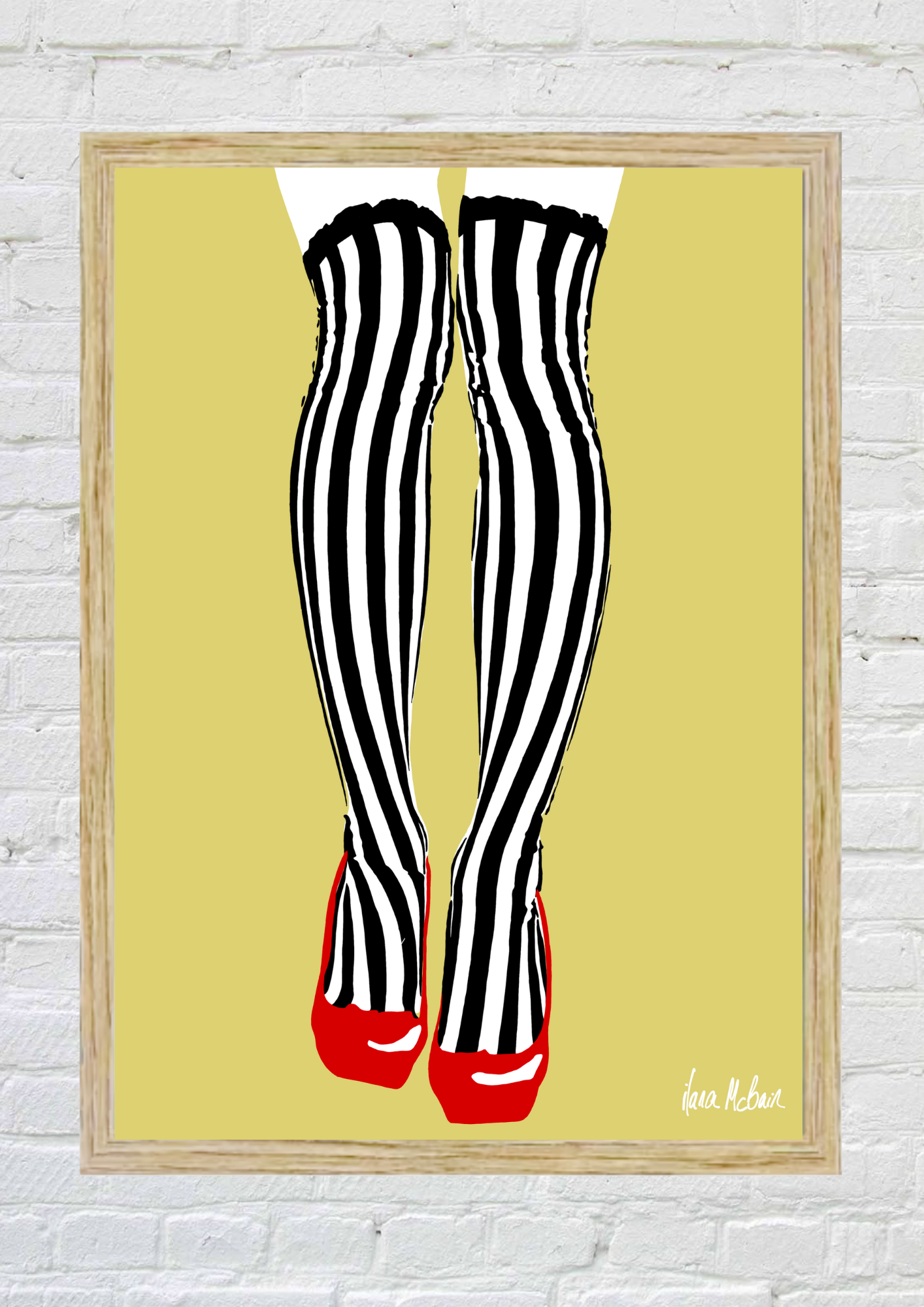 Framed artwork of black and white striped tights with red shoes on a yellow background.