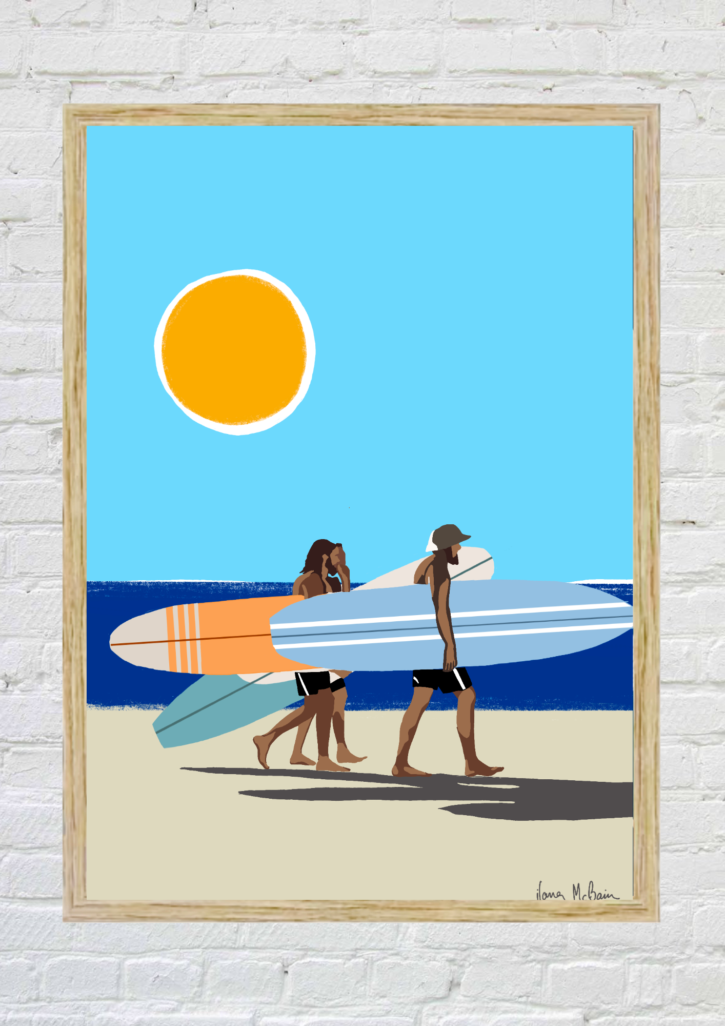 Framed artwork of three people with surfboards on a beach under a blue sky with a yellow sun.