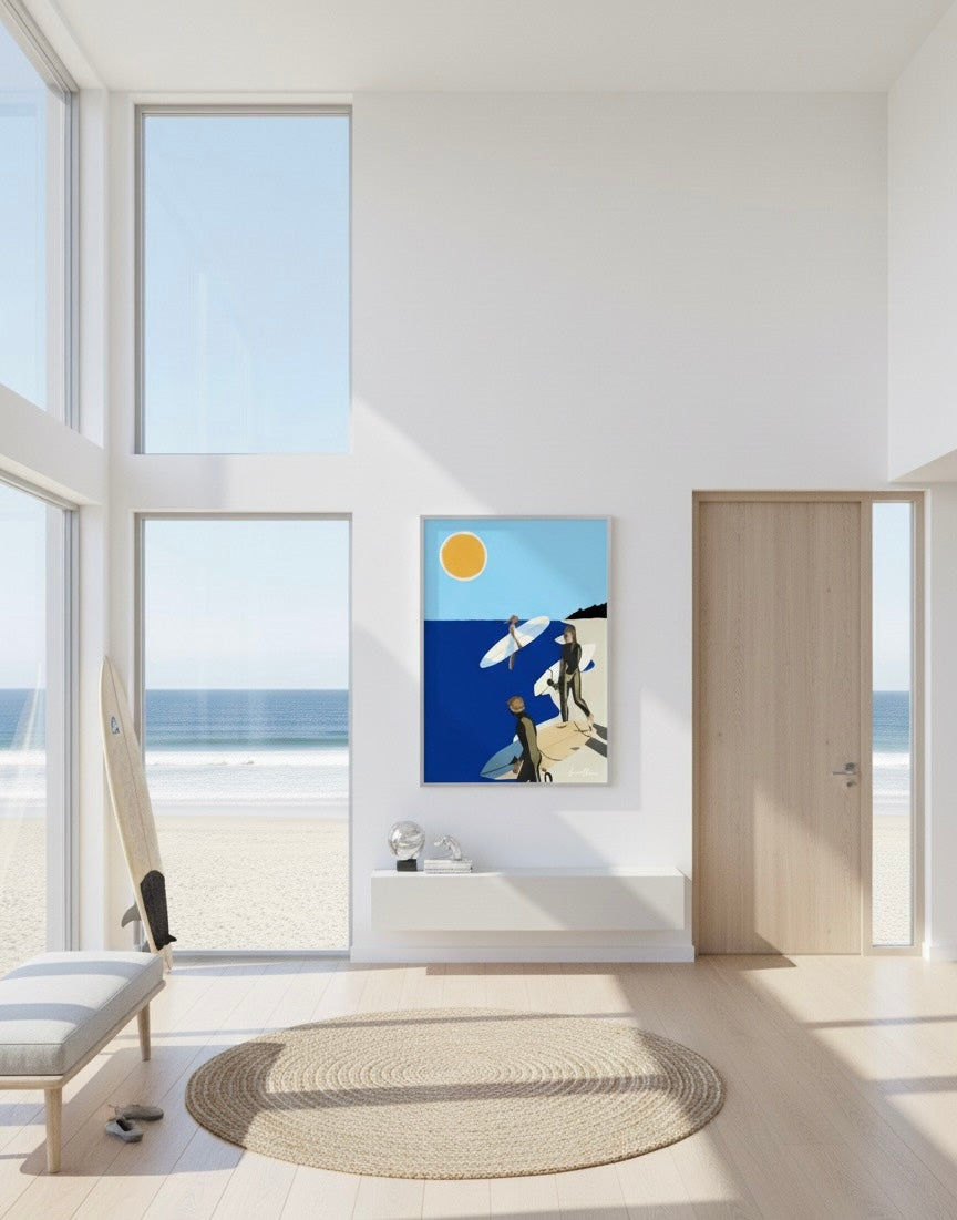 Framed art print of three surfers with surfboards on a beach under a bright sun. On a beach house entry hall wall.