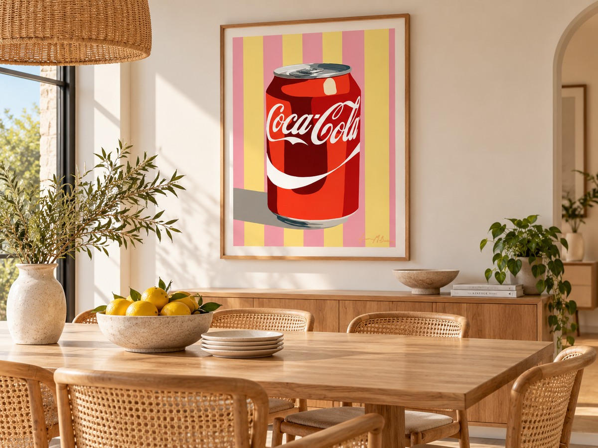 Classic Fizz pink and yellow retro cola pop art print by Ilana McBain displayed in a warm contemporary dining room with natural timber, cane chairs and neutral styling.