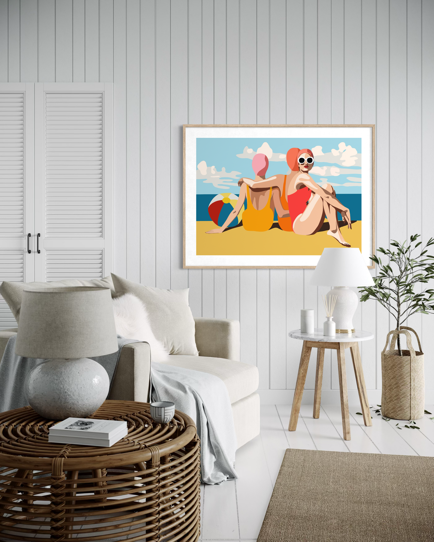 Retro-inspired beach scene artwork by Australian artist Ilana McBain showing two women sitting on the sand beside a beach ball with ocean view displayed as contemporary coastal wall decor.