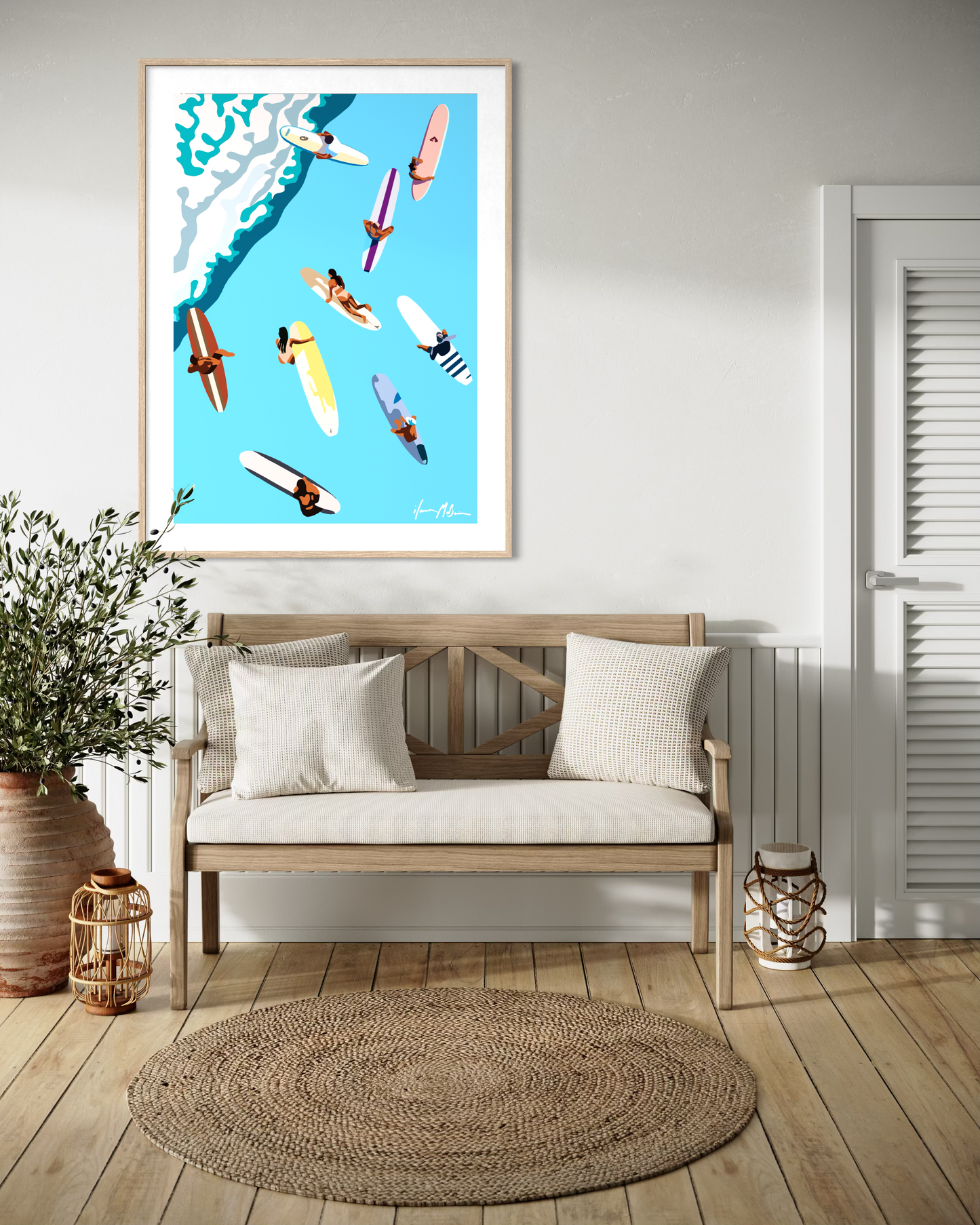 Modern coastal wall art featuring surfers on colourful surfboards viewed from above by Australian artist Ilana McBain displayed above wooden bench in beach house interior.