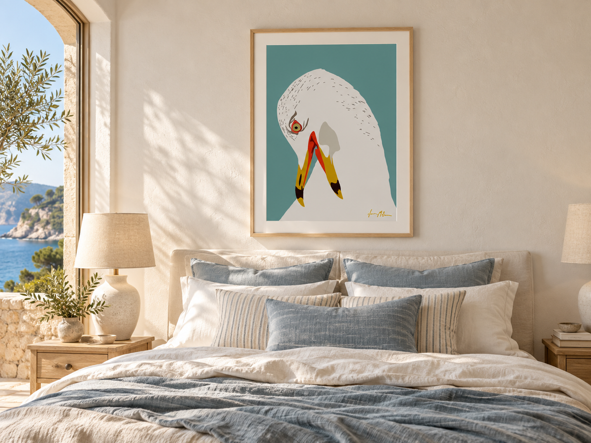 Lost in Thought contemporary seagull art print by Ilana McBain displayed above a bed in a bright coastal bedroom with natural timber, soft linen and muted blue styling.