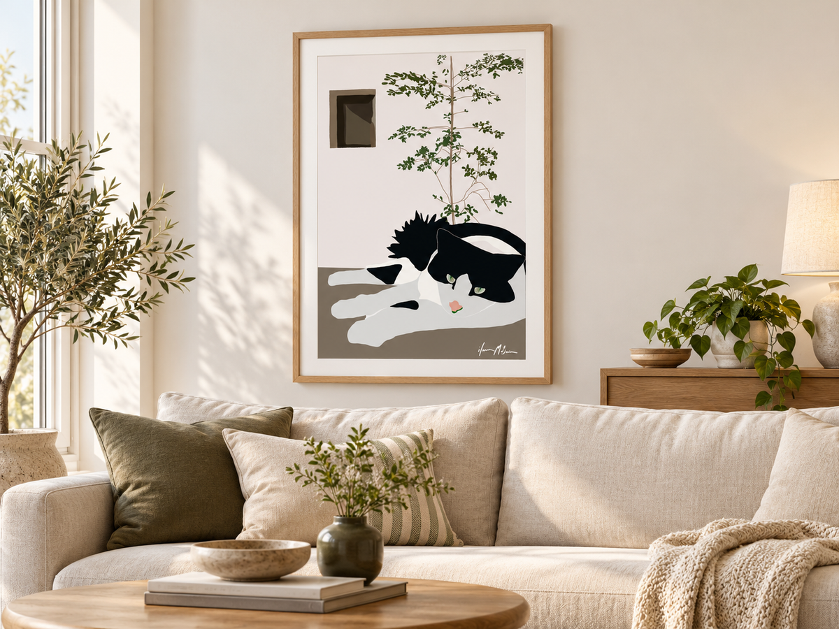 The Observer black and white cat art print by Ilana McBain displayed above a neutral sofa in a warm contemporary living room.