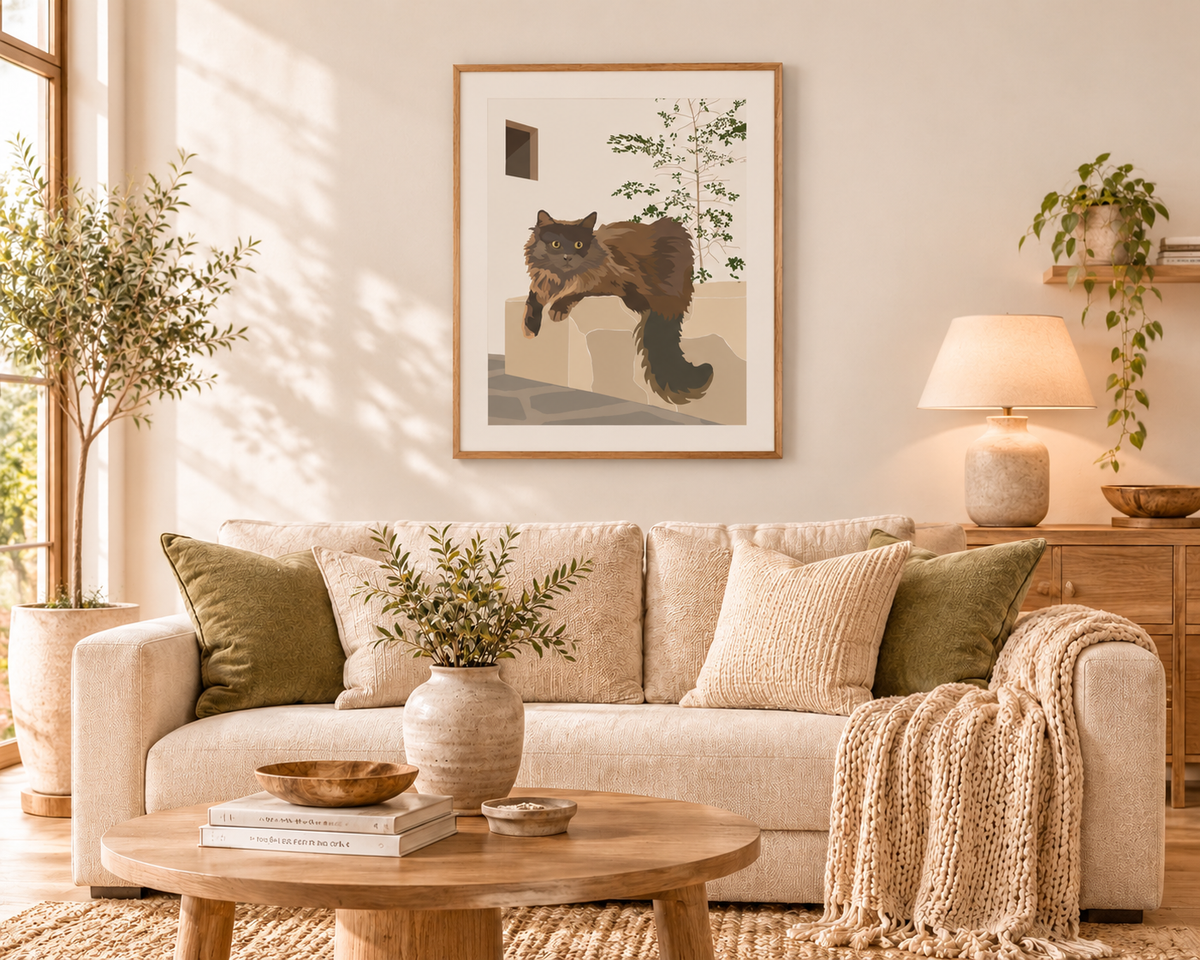 The Resident contemporary long-haired cat art print by Ilana McBain displayed above a neutral sofa in a warm modern living room with soft timber tones and restrained greenery.